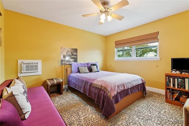 carpeted bedroom with baseboards, ceiling fan, and an AC wall unit