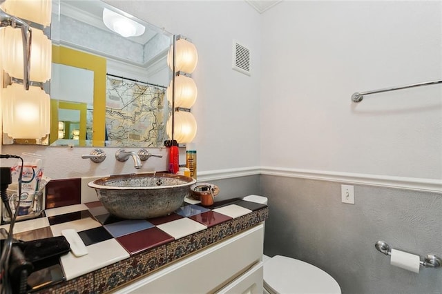 bathroom with vanity, ornamental molding, toilet, a wainscoted wall, and a shower with shower curtain