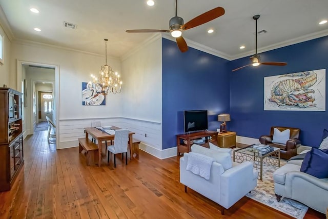 living room featuring a ceiling fan, a chandelier, hardwood / wood-style floors, crown molding, and recessed lighting