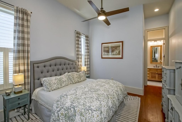 bedroom featuring wood-type flooring, multiple windows, a sink, recessed lighting, and vaulted ceiling