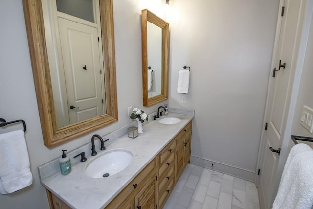 bathroom featuring double vanity and baseboards