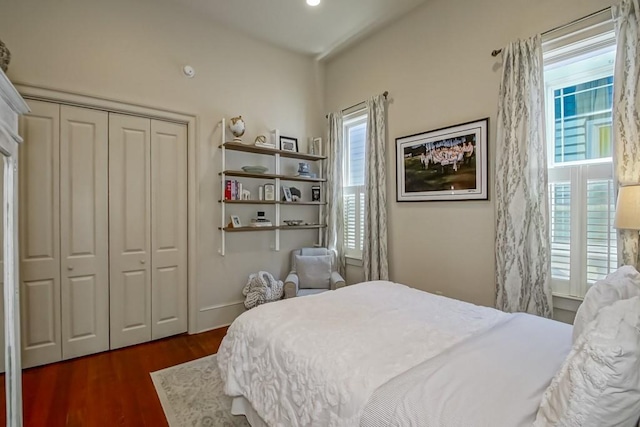 bedroom with wood finished floors and a closet