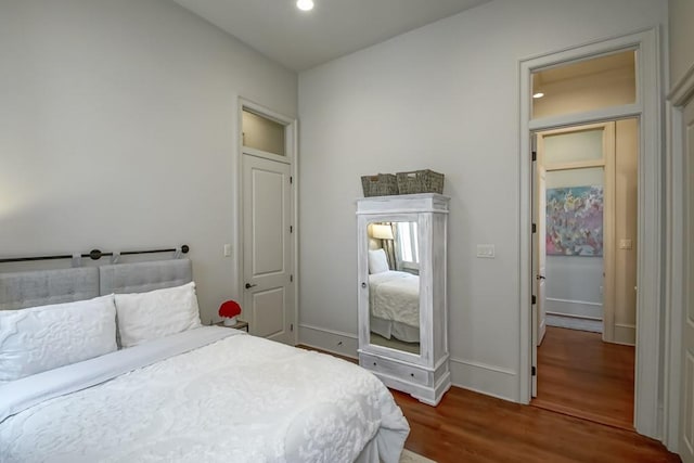 bedroom featuring wood finished floors, recessed lighting, and baseboards