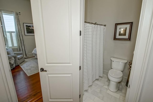 bathroom with toilet and a shower with curtain
