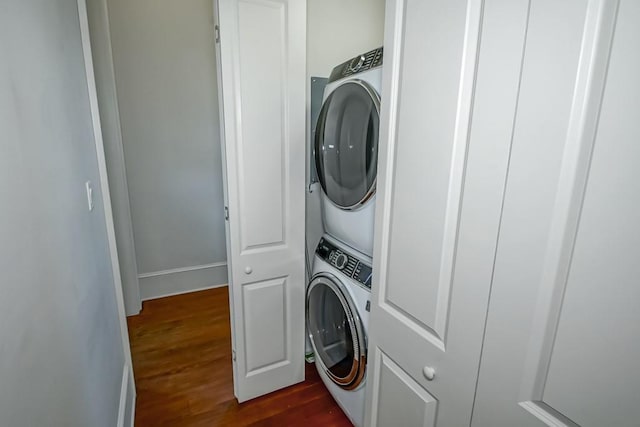 laundry room with stacked washer / drying machine and dark wood-style floors