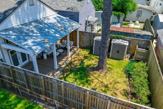 view of yard featuring a shed, a deck, an outbuilding, and french doors