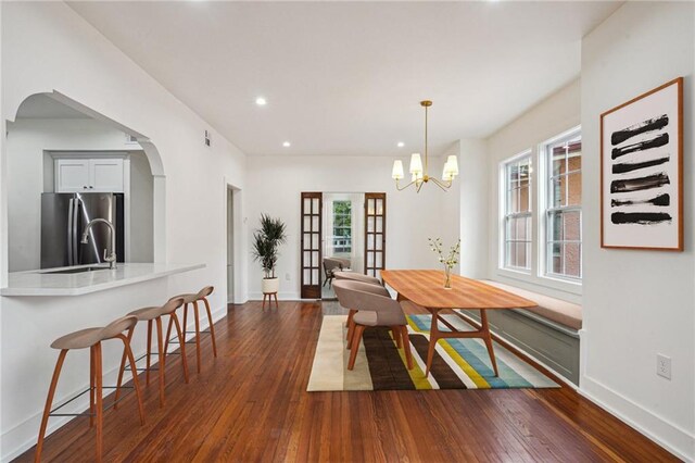 925 Picheloup Pl, New Orleans, LA 70119 - dining room with dark wood-style floors, healthy amount of natural light, recessed lighting, a chandelier, and arched walkways