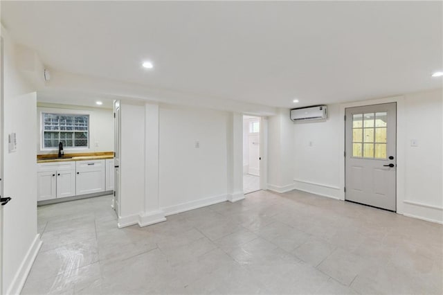 below grade area with a wall mounted air conditioner, recessed lighting, baseboards, and healthy amount of natural light