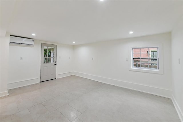 below grade area featuring a wall mounted AC, recessed lighting, baseboards, and light tile patterned flooring