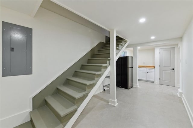 stairs featuring electric panel, recessed lighting, and baseboards