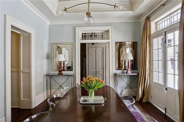interior space featuring ornamental molding, wood finished floors, and a raised ceiling