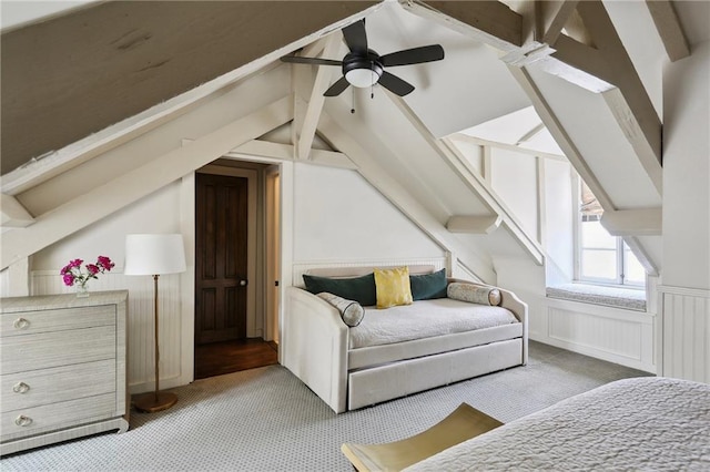 bedroom featuring light carpet, a wainscoted wall, a decorative wall, and ceiling fan