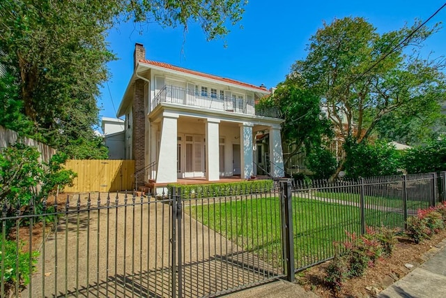 greek revival inspired property with a chimney, a fenced front yard, a porch, a front lawn, and a gate