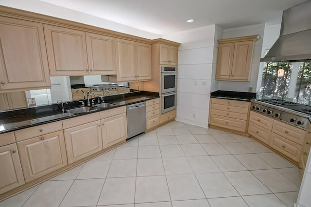 kitchen featuring stainless steel appliances, light brown cabinets, and wall chimney range hood