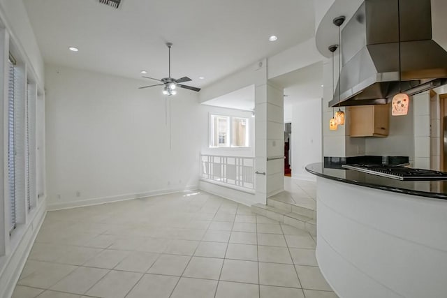 kitchen with recessed lighting, dark countertops, light tile patterned floors, and gas cooktop