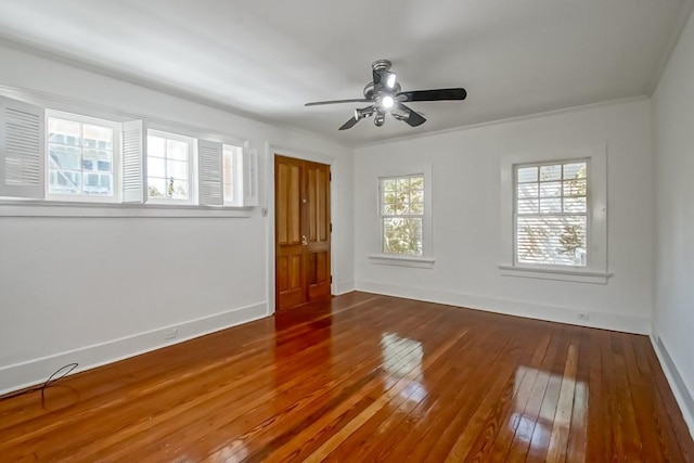 spare room with ceiling fan, ornamental molding, baseboards, and wood-type flooring
