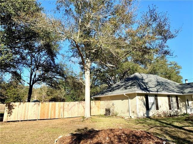 27155 Tag A Long Rd, Lacombe, LA 70445 - view of side of home with a lawn and fence