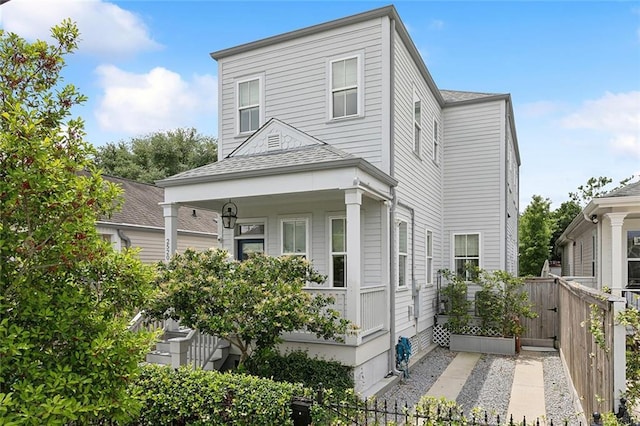 2520 Conti St, New Orleans, LA 70119 - view of side of property with fence, a shingled roof, and covered porch