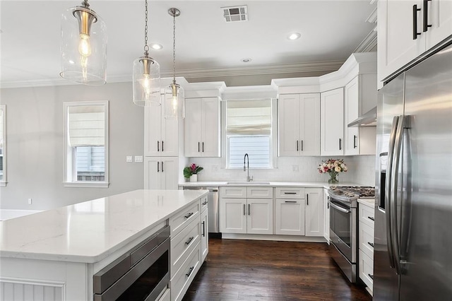 2520 Conti St, New Orleans, LA 70119 - kitchen with appliances with stainless steel finishes, a sink, ornamental molding, a center island, and wall chimney range hood