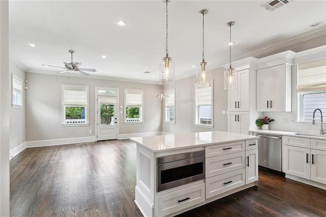 2520 Conti St, New Orleans, LA 70119 - kitchen featuring appliances with stainless steel finishes, a sink, crown molding, light countertops, and open floor plan
