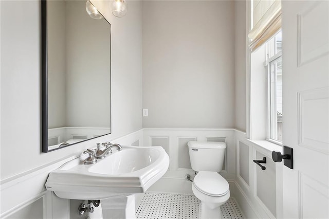 2520 Conti St, New Orleans, LA 70119 - bathroom with wainscoting, toilet, a decorative wall, and a sink