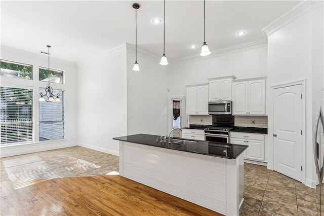 400 Brown Thrasher Loop, Madisonville, LA 70447 - kitchen featuring crown molding, stainless steel appliances, dark countertops, and a chandelier