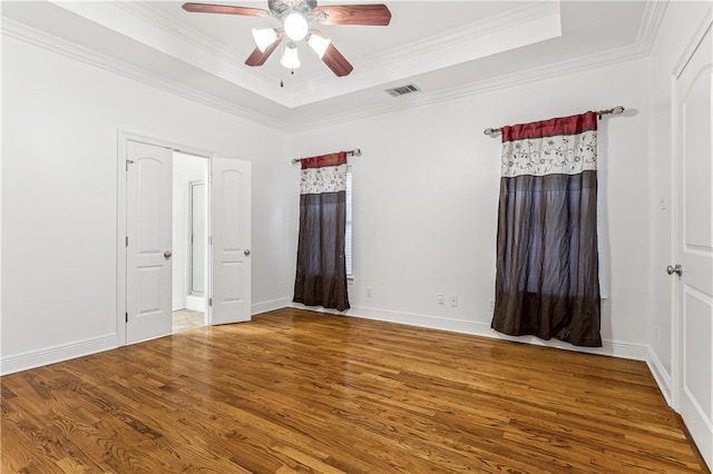 400 Brown Thrasher Loop, Madisonville, LA 70447 - unfurnished bedroom with a tray ceiling, visible vents, wood finished floors, and ornamental molding