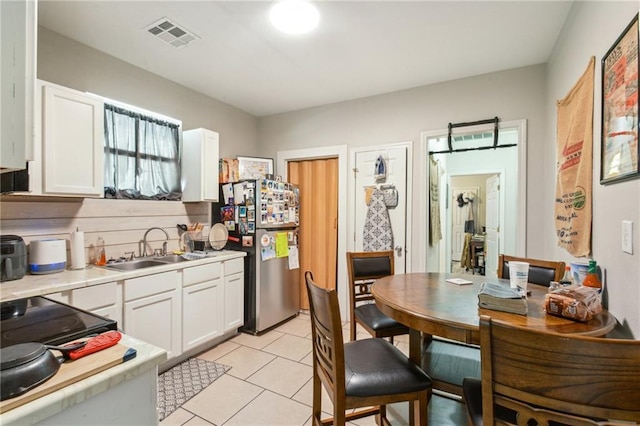 3619-25 Delachaise St, New Orleans, LA 70125 - kitchen featuring a sink, freestanding refrigerator, white cabinetry, visible vents, and light countertops