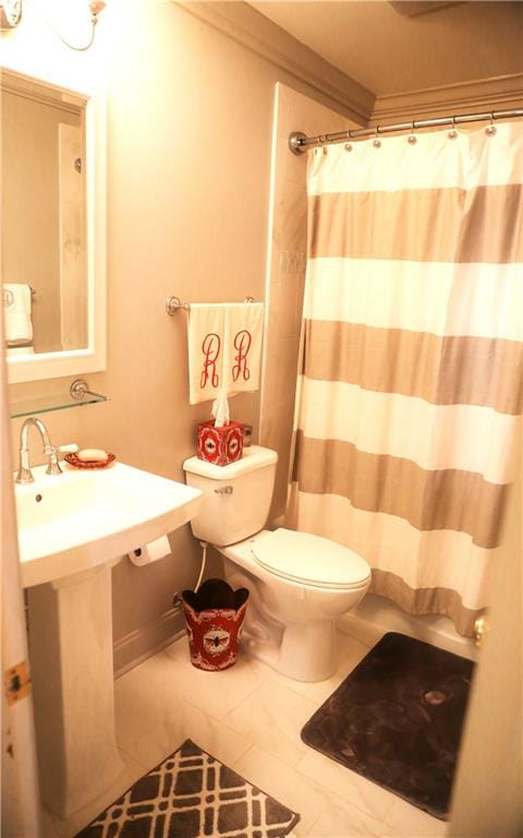 bathroom featuring toilet, a shower with shower curtain, and tile patterned flooring