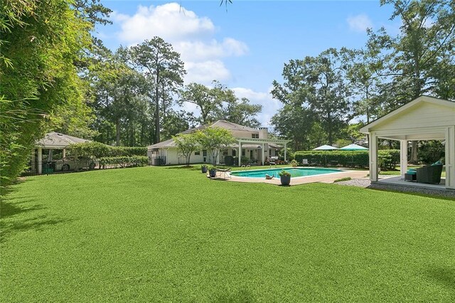 72 Riverdale Dr, Covington, LA 70433 - view of grassy yard featuring an outbuilding, an outdoor pool, a patio area, and a storage structure