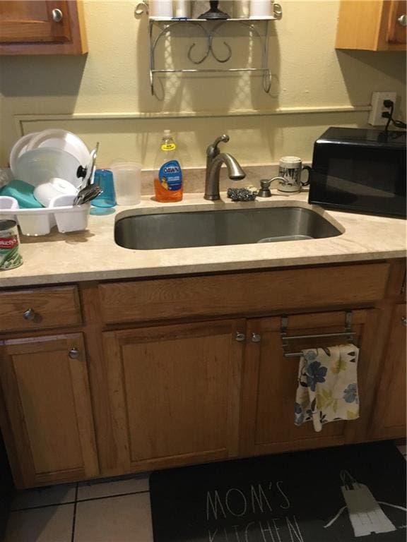 201315 Touro St, New Orleans, LA 70116 - kitchen featuring black microwave, light countertops, and brown cabinetry