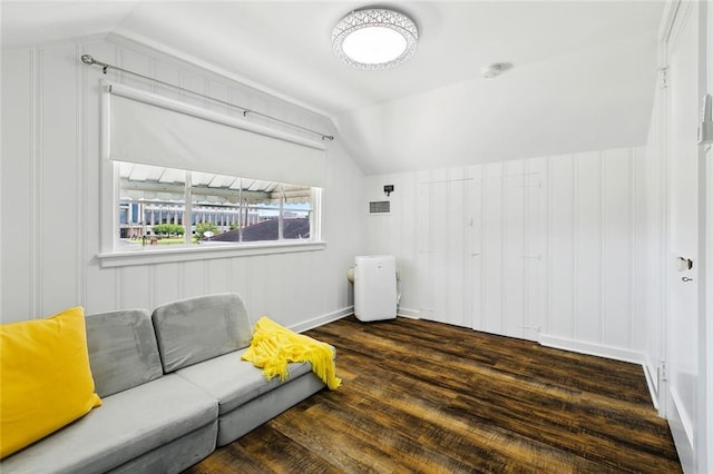 living area featuring vaulted ceiling and wood finished floors