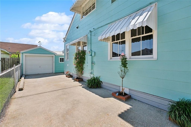 704 Sumner St, New Orleans, LA 70114 - view of property exterior featuring an outdoor structure, concrete driveway, and a detached garage