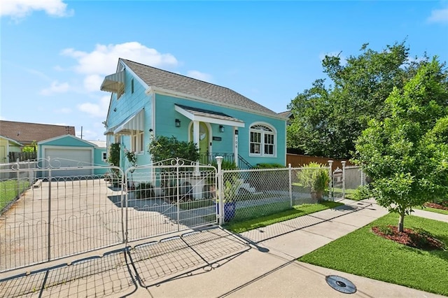 704 Sumner St, New Orleans, LA 70114 - shotgun-style home featuring a fenced front yard, a garage, an outdoor structure, and roof with shingles
