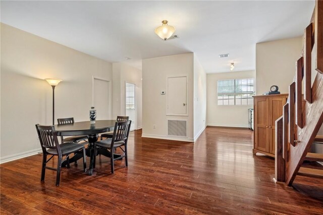 dining space featuring stairs, dark wood-style flooring, and baseboards