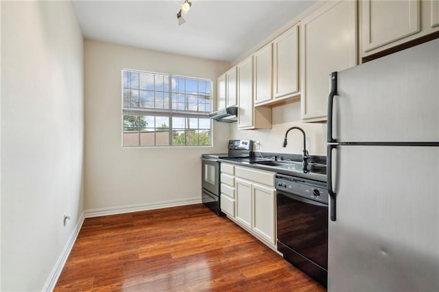kitchen featuring freestanding refrigerator, stainless steel electric range, black dishwasher, a sink, and under cabinet range hood