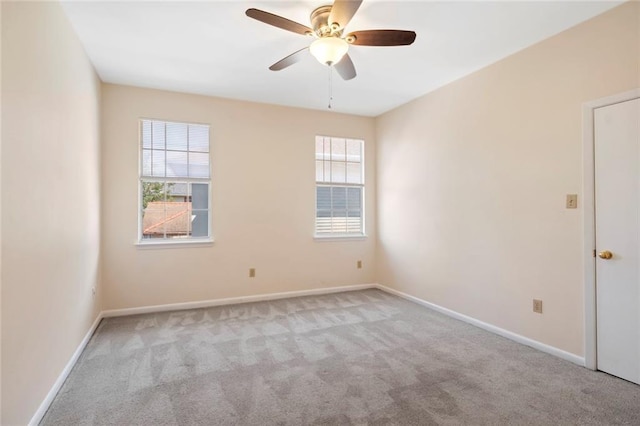 carpeted empty room featuring healthy amount of natural light, a ceiling fan, and baseboards