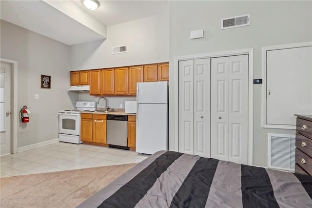 kitchen with white appliances, a towering ceiling, light tile patterned floors, light countertops, and baseboards