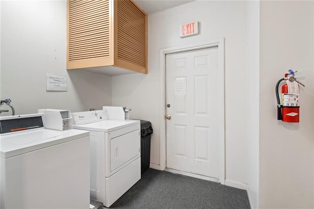 laundry area featuring cabinet space, washer and clothes dryer, dark carpet, and baseboards
