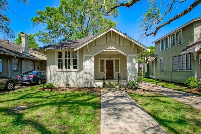 bungalow featuring a front yard, stucco siding, and crawl space