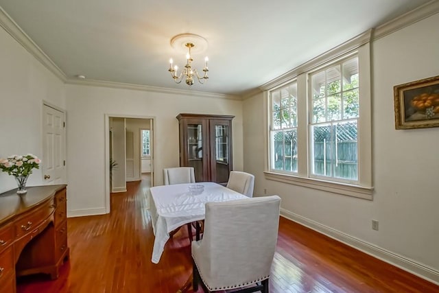 dining room with crown molding, an inviting chandelier, dark wood-style flooring, and baseboards