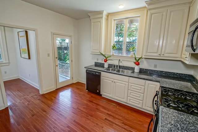 kitchen featuring baseboards, a sink, dark stone countertops, black appliances, and dark wood-style floors