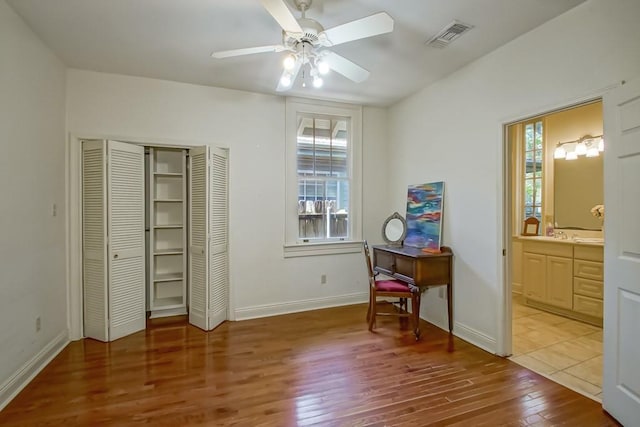 bedroom featuring a closet, baseboards, visible vents, and wood finished floors
