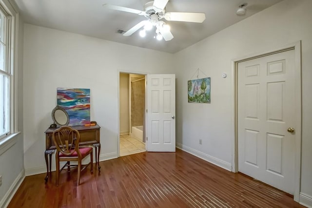 bedroom featuring a ceiling fan, visible vents, wood finished floors, and baseboards