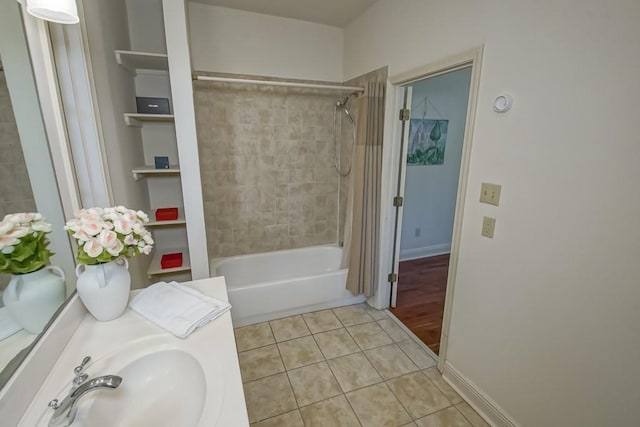 bathroom featuring tile patterned floors, shower / tub combo with curtain, baseboards, and a sink