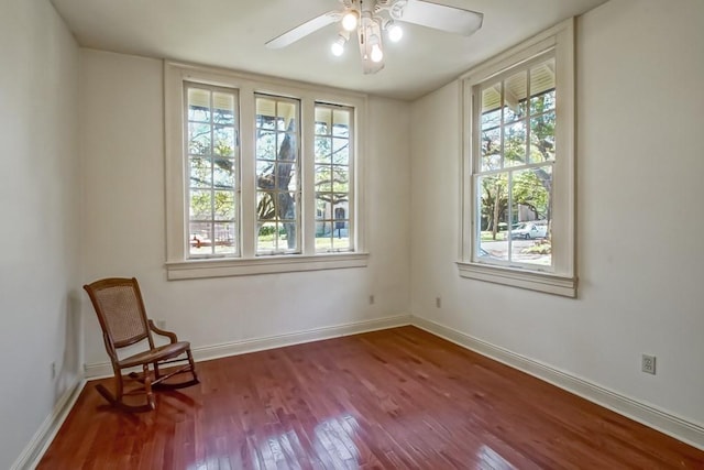 unfurnished room featuring a ceiling fan, baseboards, and wood finished floors