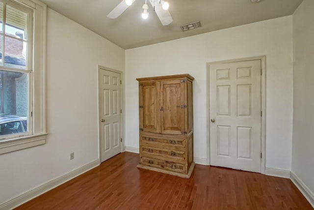 bedroom with visible vents, wood finished floors, baseboards, and ceiling fan