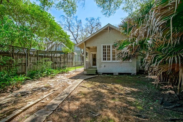 back of property featuring stucco siding and fence
