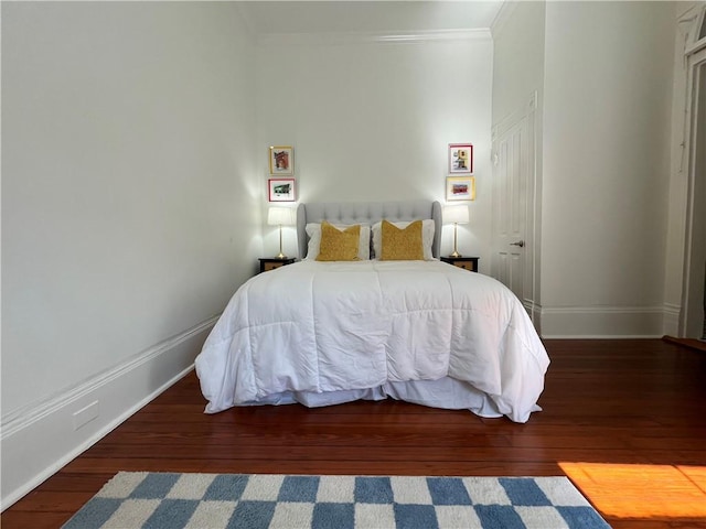 bedroom featuring baseboards, ornamental molding, and hardwood / wood-style flooring