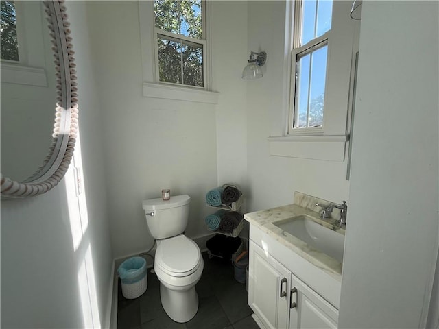 half bathroom featuring tile patterned floors, toilet, and vanity